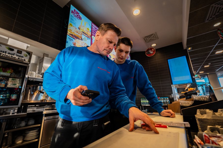 Zwei Servicetechniker der GK Fullservice bei der Fehlersuche an einem Gerät